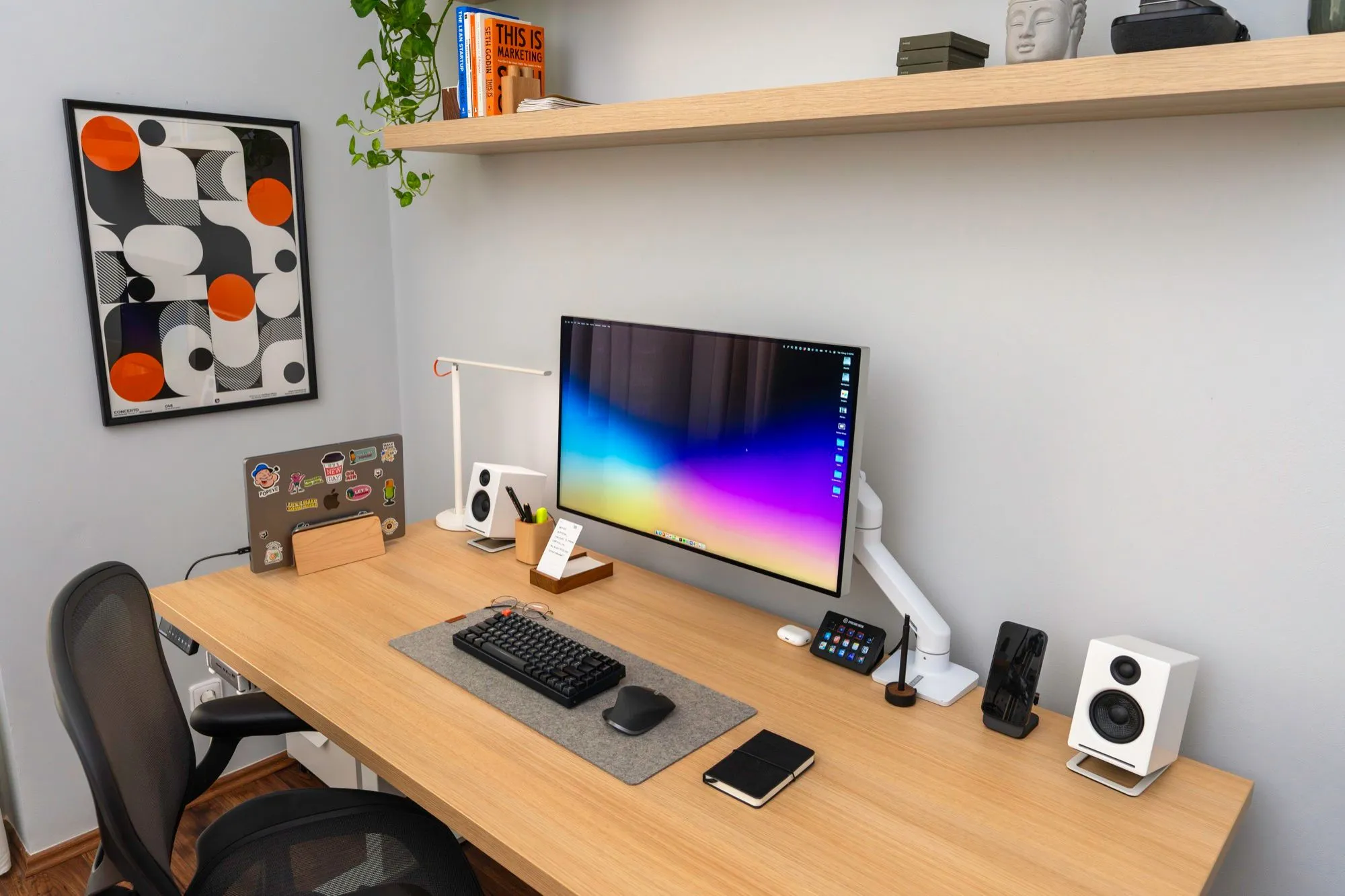 The full desk with the monitor, speakers and shelves